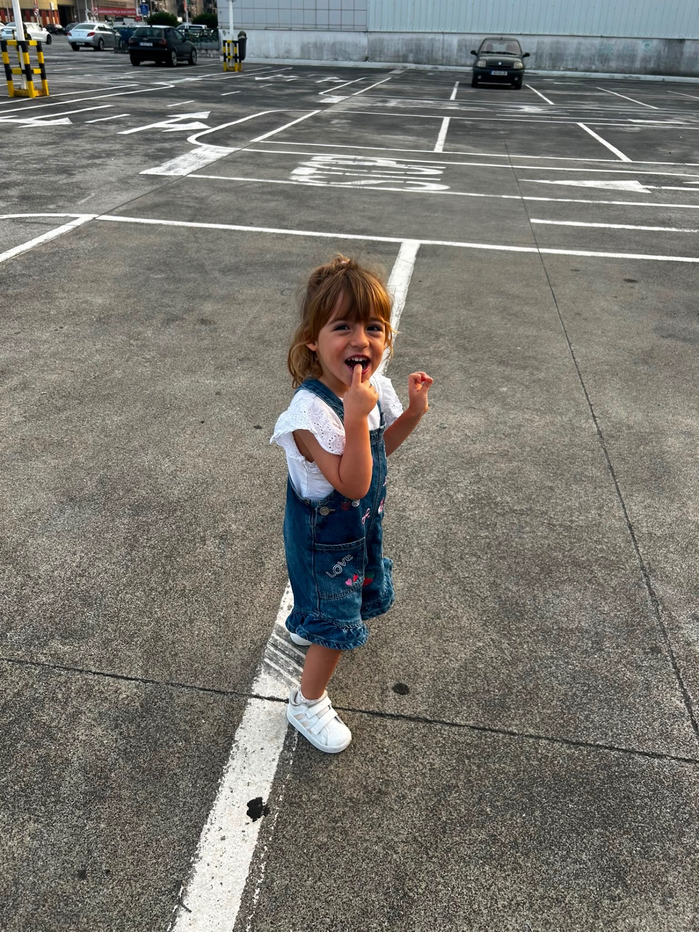 Matilde, a 3-year-old girl, in an outdoor car park